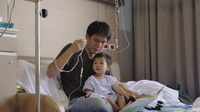 可爱的亚洲孩子感染了病毒，他照顾好自己，和父亲一起看书，在医院接受抗生素药物和输液盐水，等待康复。婴