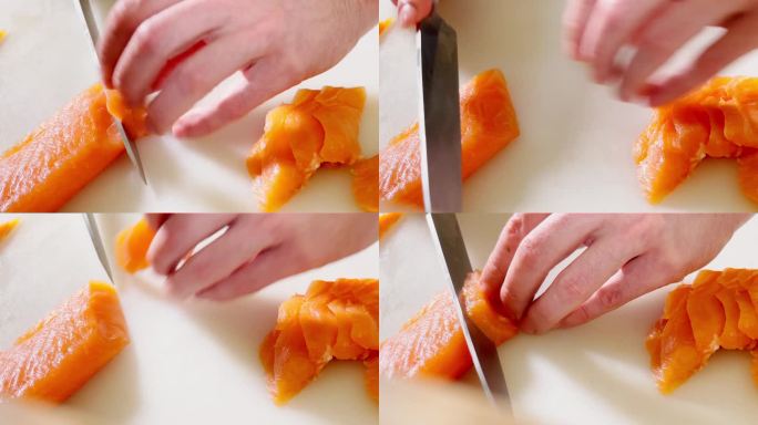 厨师用锋利的刀在白色砧板上切新鲜的大西洋鲑鱼片。专业职业，工作日，健康食品准备和餐饮业4K特写镜头。
