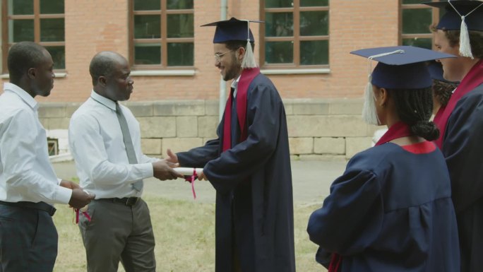 男教授与毕业生握手并颁发毕业证书