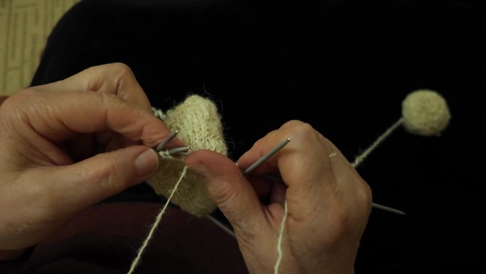 奶奶熟练地用长矛手工制作羊毛袜子，从天然羊毛中注入舒适和温暖，手工制作传统