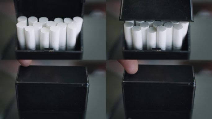 他合上一盒黑色的香烟，慢镜头。戒烟的概念。可用于广告。