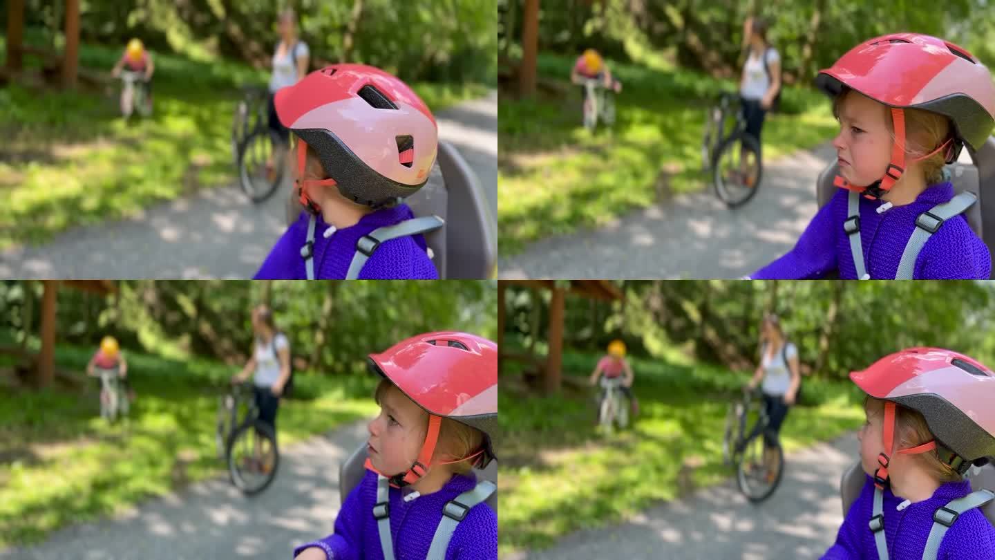 一个年轻的家庭带着一个不快乐的孩子在山上骑车