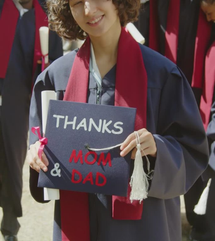 毕业时手持帽子感谢父母的女子肖像