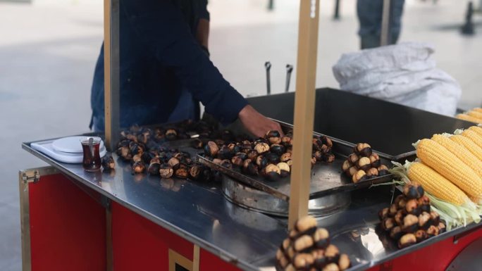 一名土耳其男子开着街头马车向游客兜售烤栗子和煮香玉米