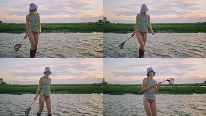 垂钓的女孩在夏天的傍晚走在河边。平静放松的模特拿着勺子