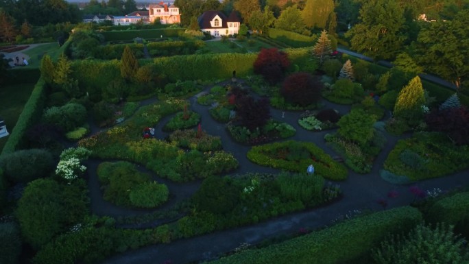 华丽的房子，有一个令人惊叹的大花园，早晨的阳光照在房子上。无人机拍摄。