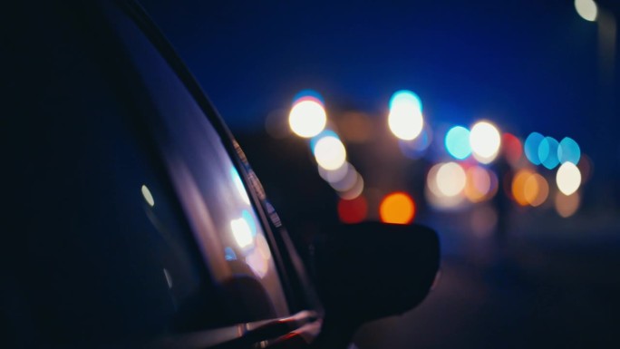 SLO MO汽车侧视镜在道路与散焦消防车灯的背景在晚上