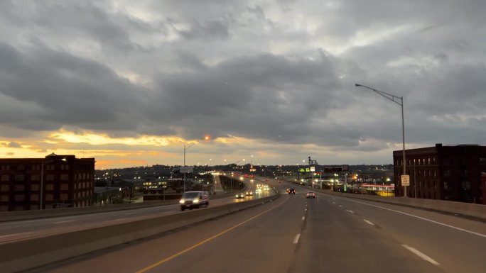 在密苏里州堪萨斯城的州际公路上，日落时分，天空中有灰色的云