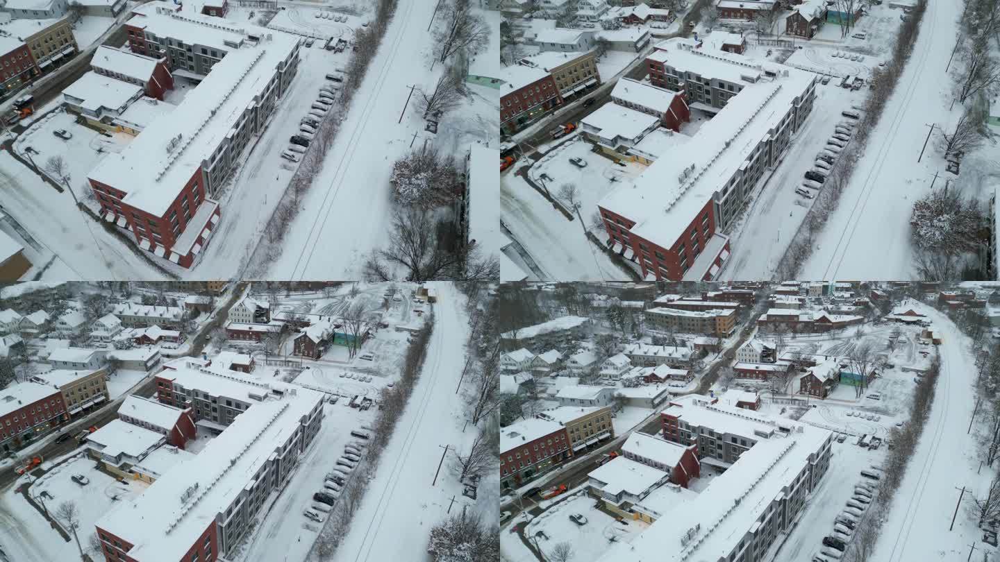 无人机倾斜显示市区主要街道在暴风雪后清理道路的铲雪车