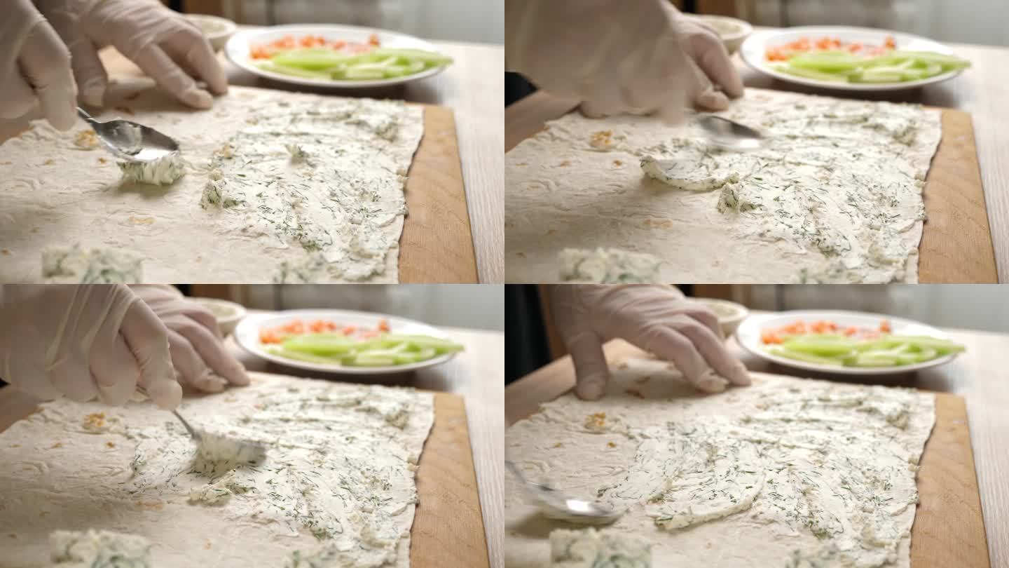 在皮塔饼上放上一层准备好的奶酪。准备鱼和蔬菜卷