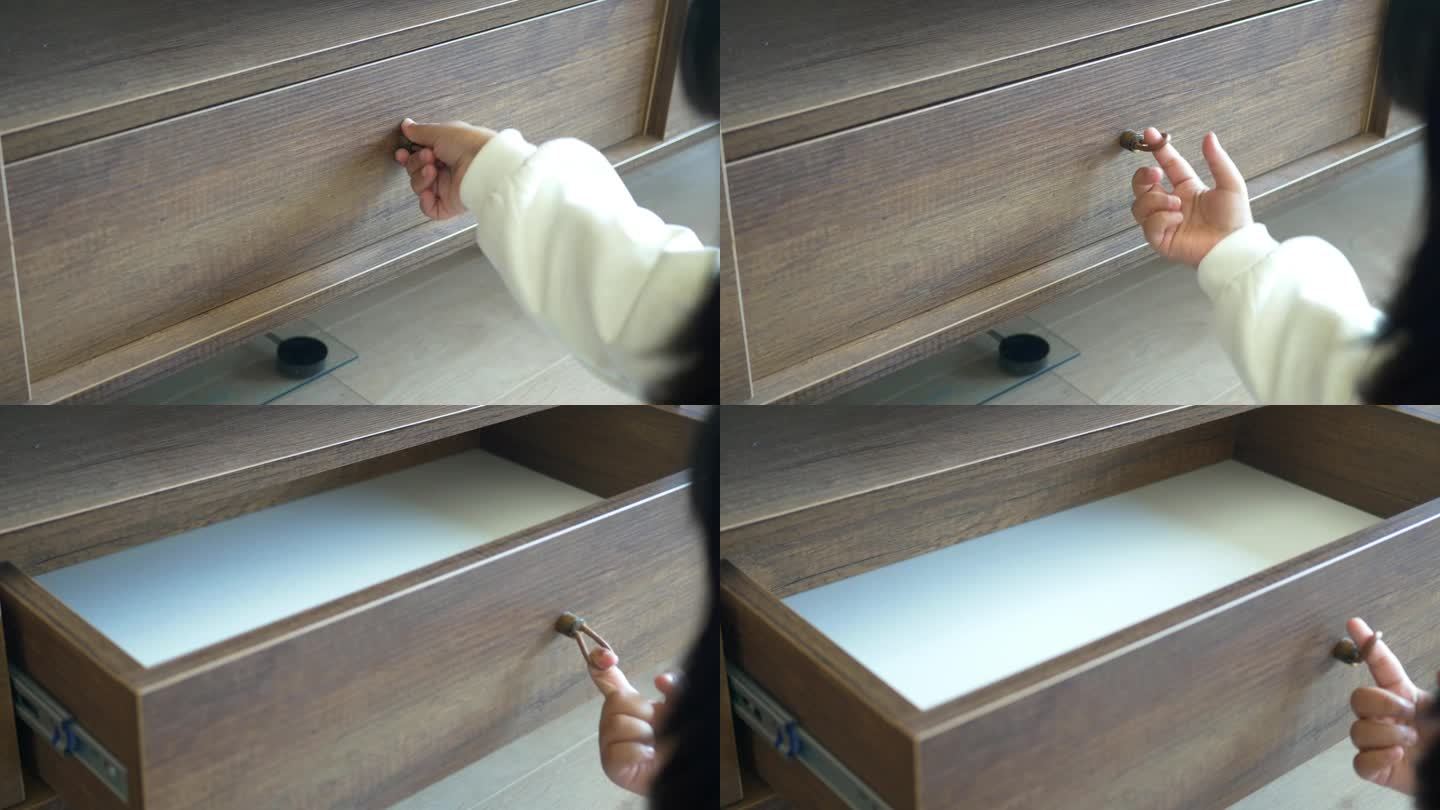 儿童手打开橱柜中木制抽屉的后视图