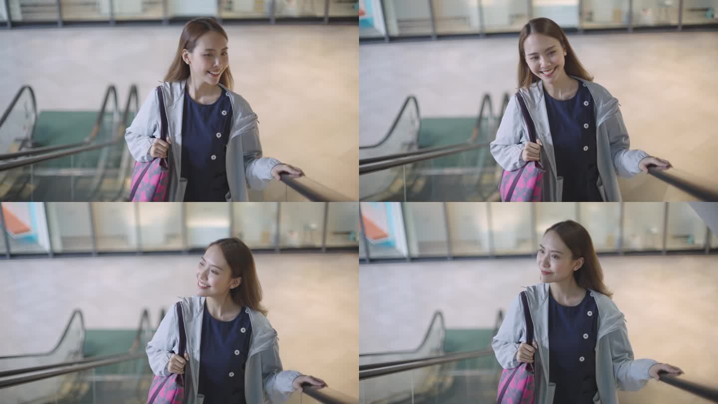年轻美丽的亚洲护士在医院完成工作后，穿着工作服，在商场的自动扶梯上。专业职业人员以统一的日常生活方式