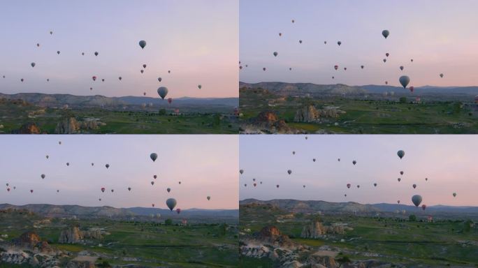 热气球飞过土耳其卡帕多西亚的山景。