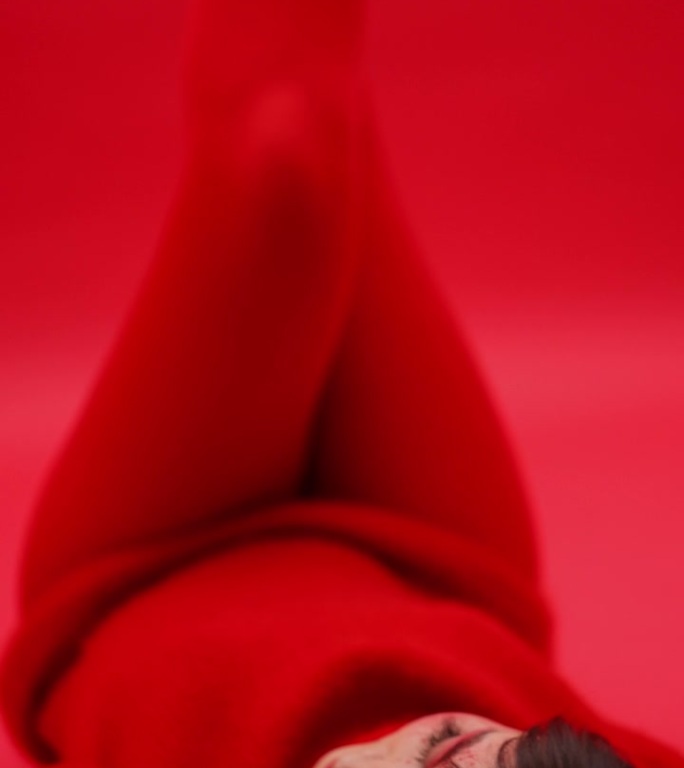 性感的亚洲艺妓女孩摆姿势在红色背景与腿在红色连裤袜。垂直视频。