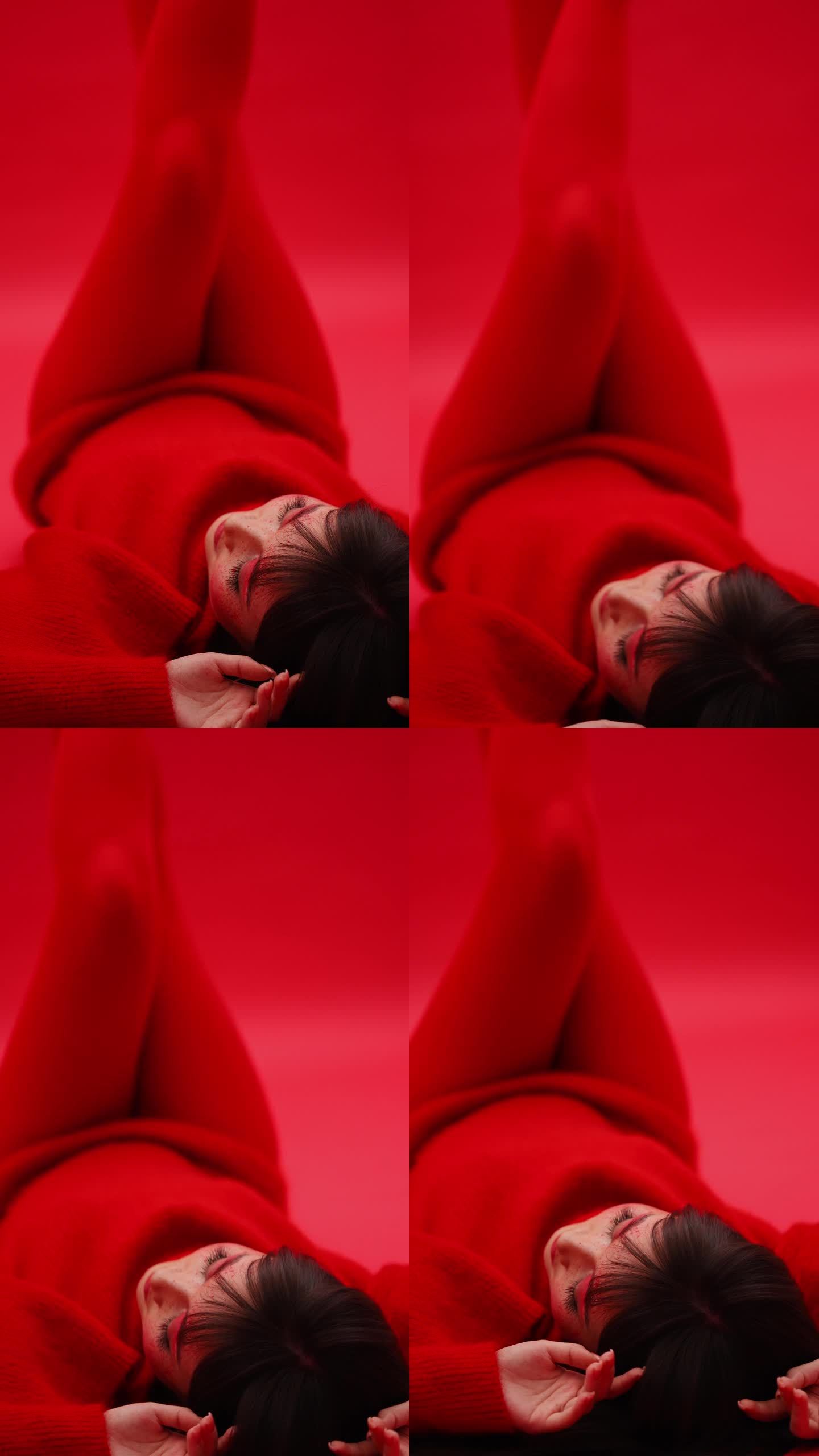 性感的亚洲艺妓女孩摆姿势在红色背景与腿在红色连裤袜。垂直视频。