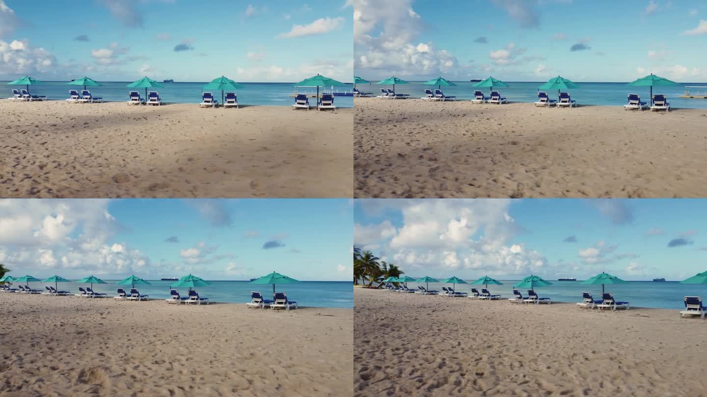 在一个晴朗的早晨，低角度无人机拍摄了沙滩椅和遮阳伞