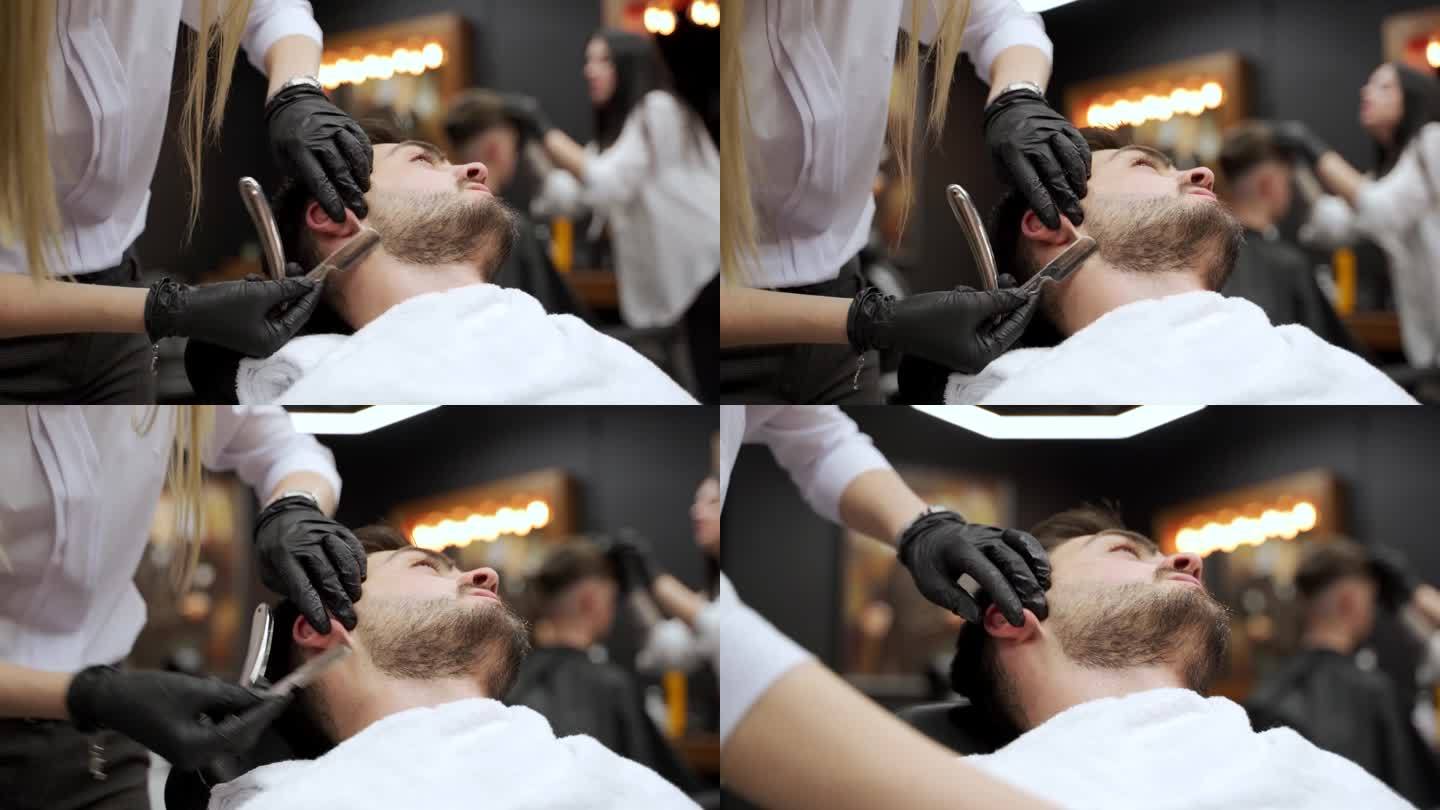 专业女理发师在高档理发店用剃刀给顾客刮胡子。男人斜倚着梳妆，造型师专注于面部毛发，奢华的背景。客户放