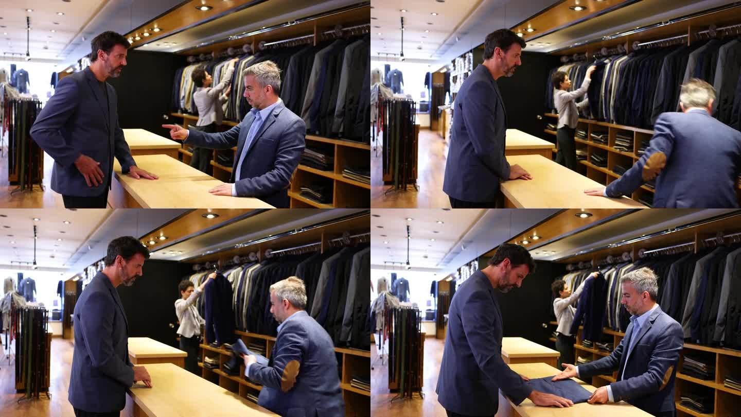 一位白人顾客在一家男士百货商店要求搭配他的商务夹克的裤子