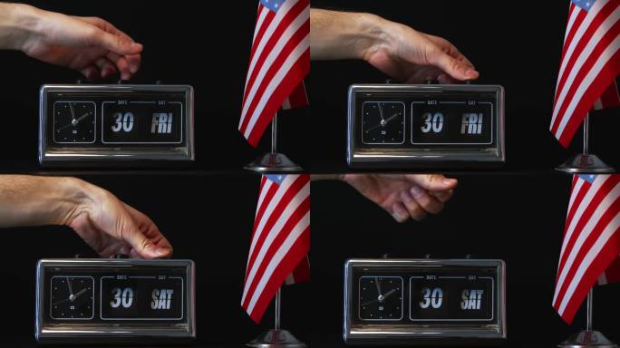 手动调整一个老式翻盖时钟，显示第30天，并有一面美国国旗，代表准时日期跟踪在美国文化和商业中的重要性