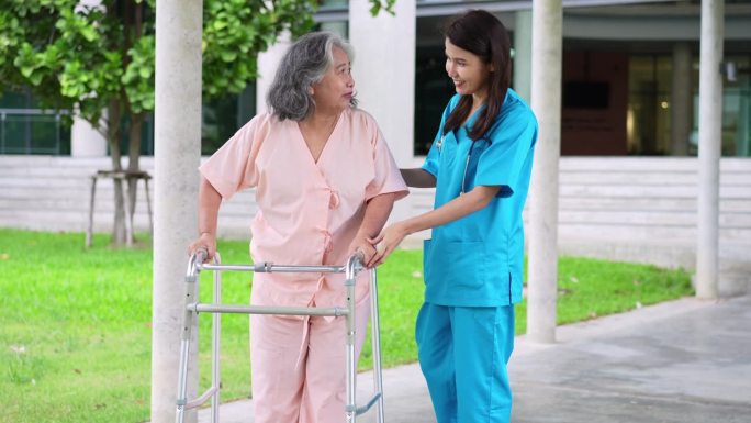 亚洲细心的照顾者或护士照顾坐在轮椅上的亚洲老人。幸福退休的概念，由照顾者照顾，储蓄和高级健康保险。老