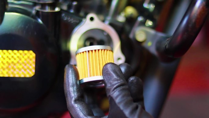汽车修理工更换摩托车机油滤清器，给摩托车装上新的机油滤清器进行保养