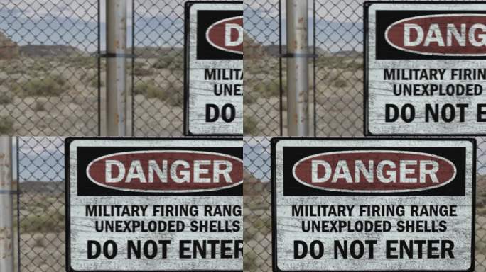 高质量的3D CGI渲染在一个高安全设施的铁丝网在沙漠场景，与危险军事射击场的标志