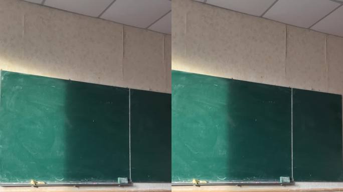 教室里有一块绿色的板子，课桌都看得见，阳光照在板子上。空无一人的教室，微粒飞扬，阳光从公立学校的窗户