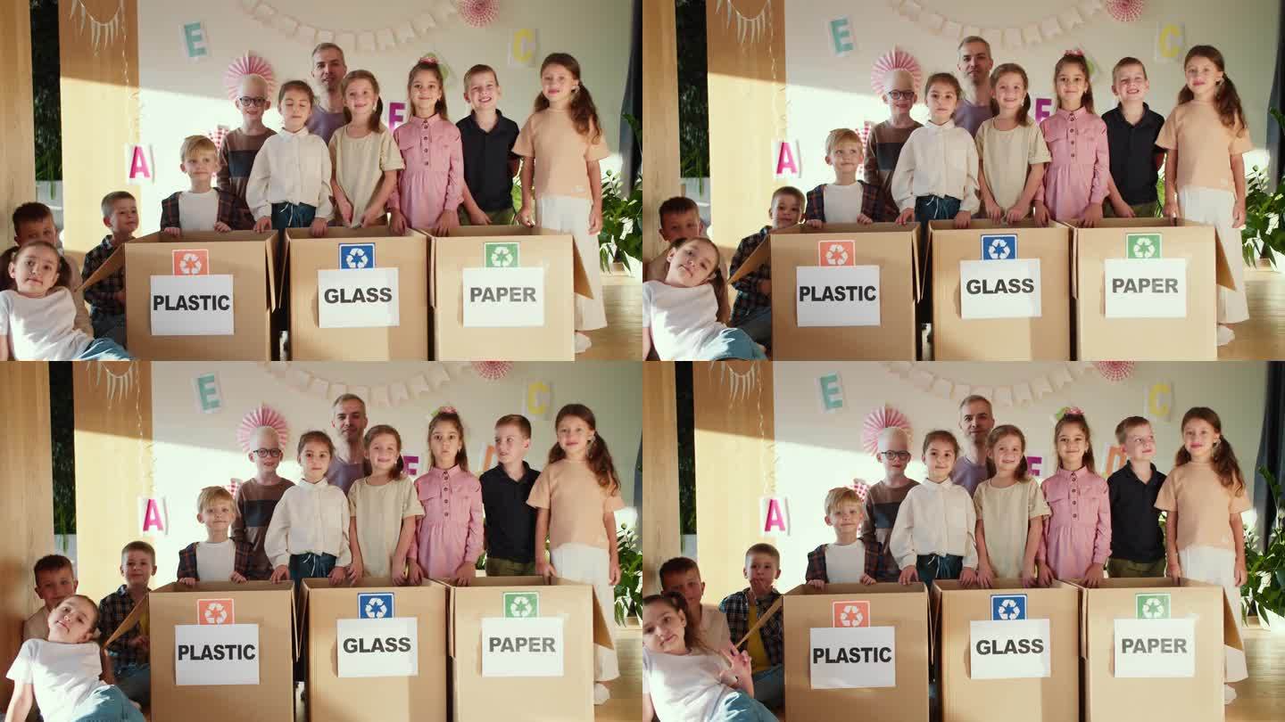 快乐的孩子们和他们的老师在俱乐部里为准备上学而专门分类垃圾的盒子旁的照片。图为一群正在学习分类垃圾的