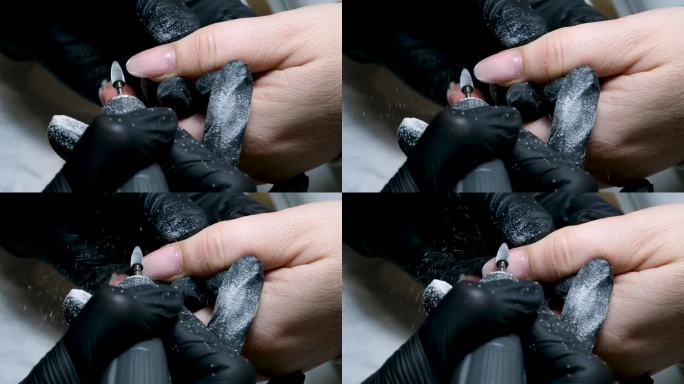 美甲师将指甲的角质层加工成一种特殊的设备，使用指甲刀清洁指甲。宏。特写卸妆啫喱，美甲机，女师傅。美甲