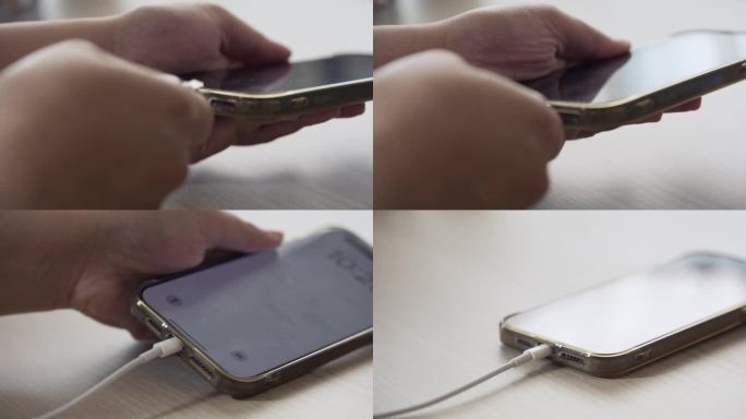 双手插上充电线给手机电池充电，放在桌上