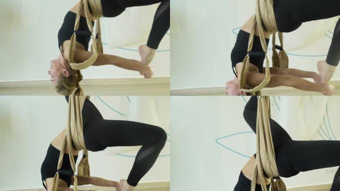 女士用瑜伽秋千表演架桥姿势的空中变化