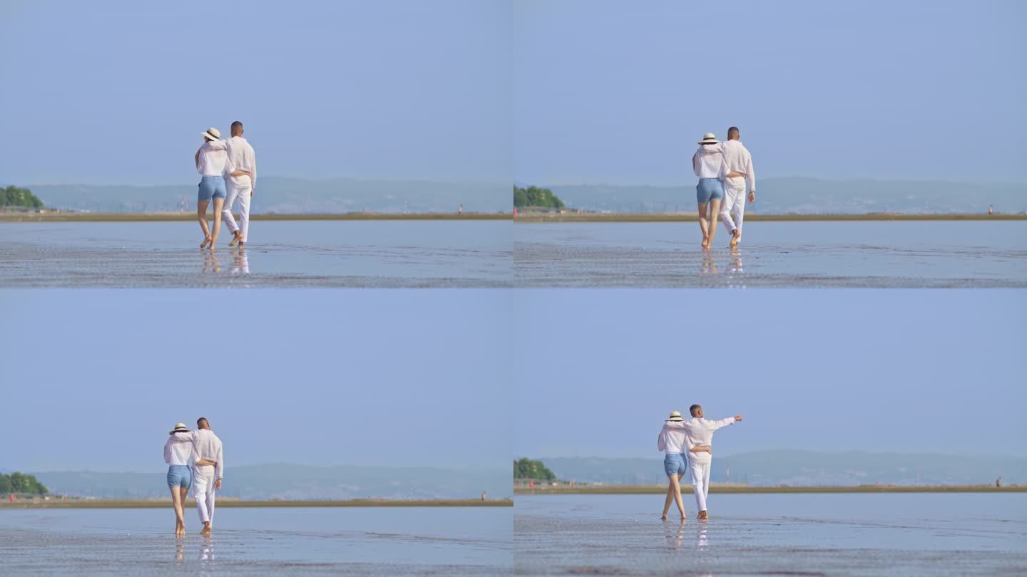 一对情侣在阳光明媚的海滩上拥抱着散步
