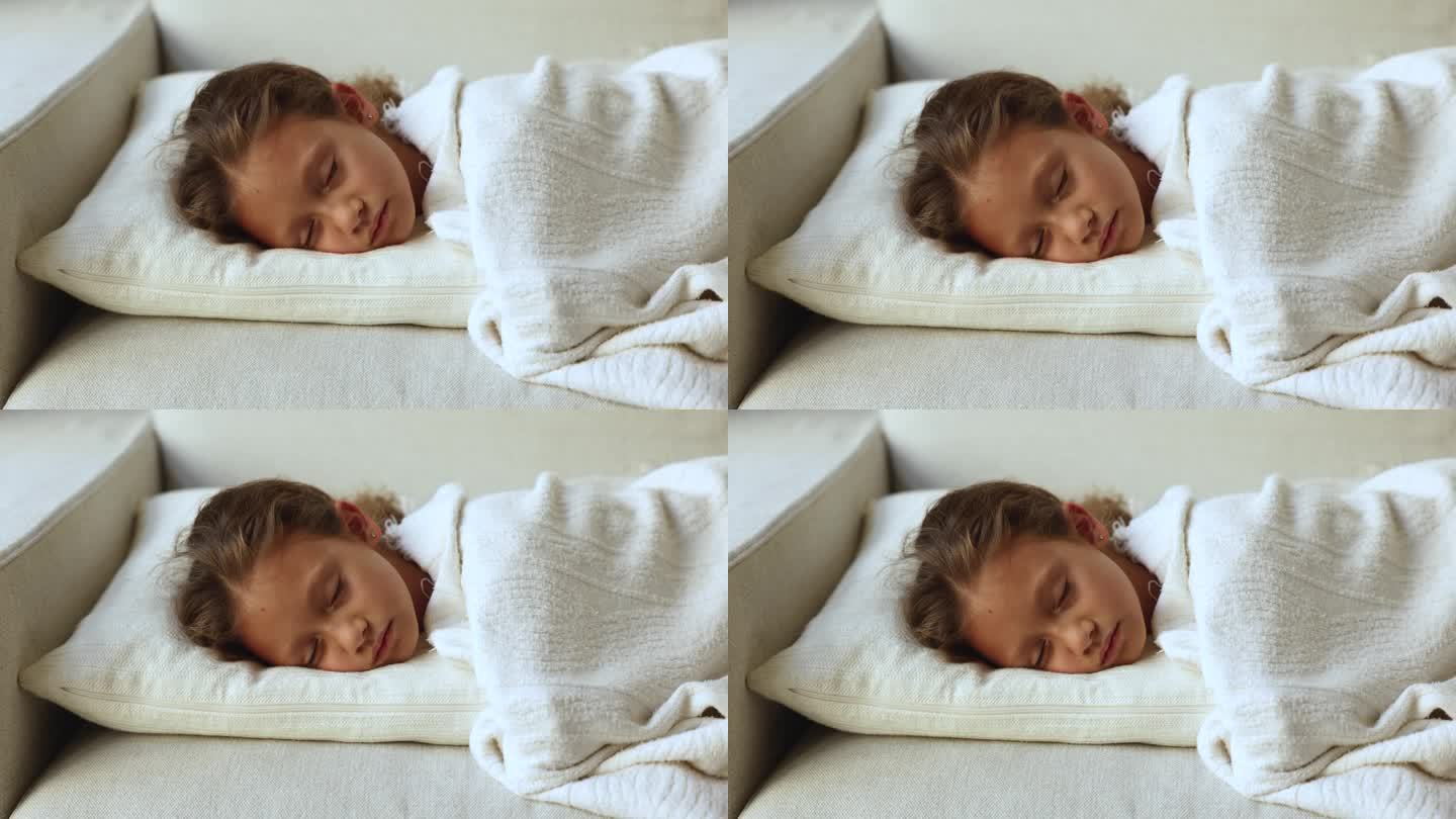 小女孩睡在铺着白色格子布的沙发上
