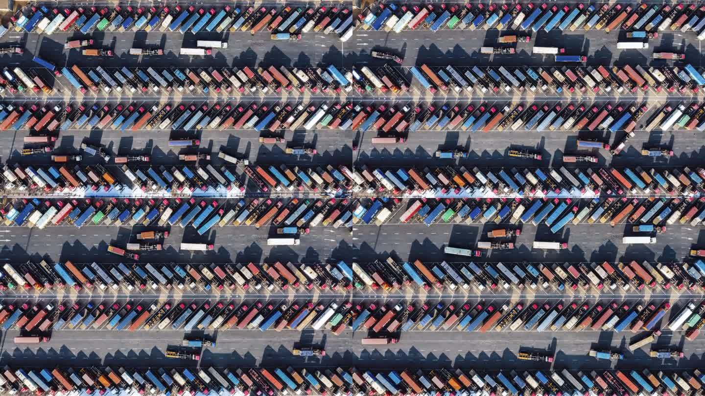 T/L鸟瞰图，在港口行驶的一排排卡车和拖车