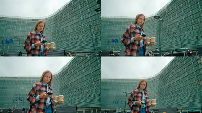 布鲁塞尔欧盟现代办公室使用手机应用程序“官员女士端着咖啡散步”