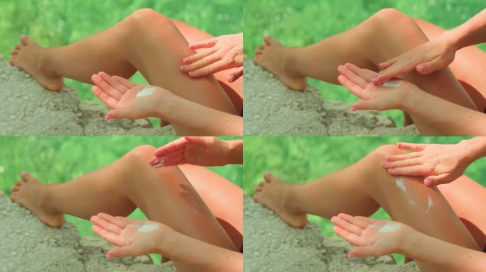 在户外涂抹防晒霜。一个人在腿上涂抹面霜，夏日沙滩上护肤、防晒的重要性。