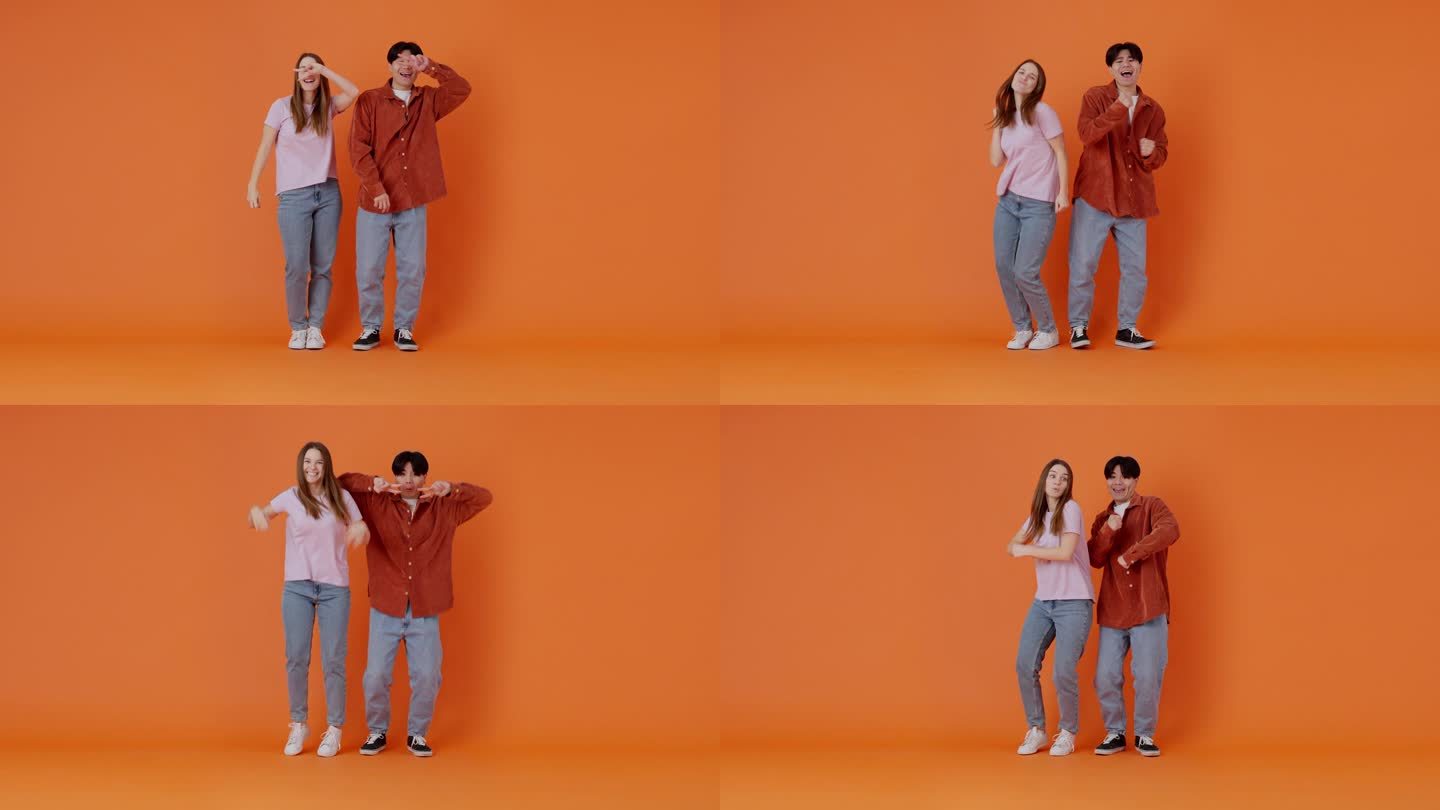 一对年轻的女士和亚洲男人在橙色房间里跳舞
