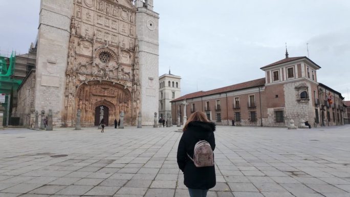 一名女子走在西班牙巴利亚多利德市的圣巴勃罗修道院前