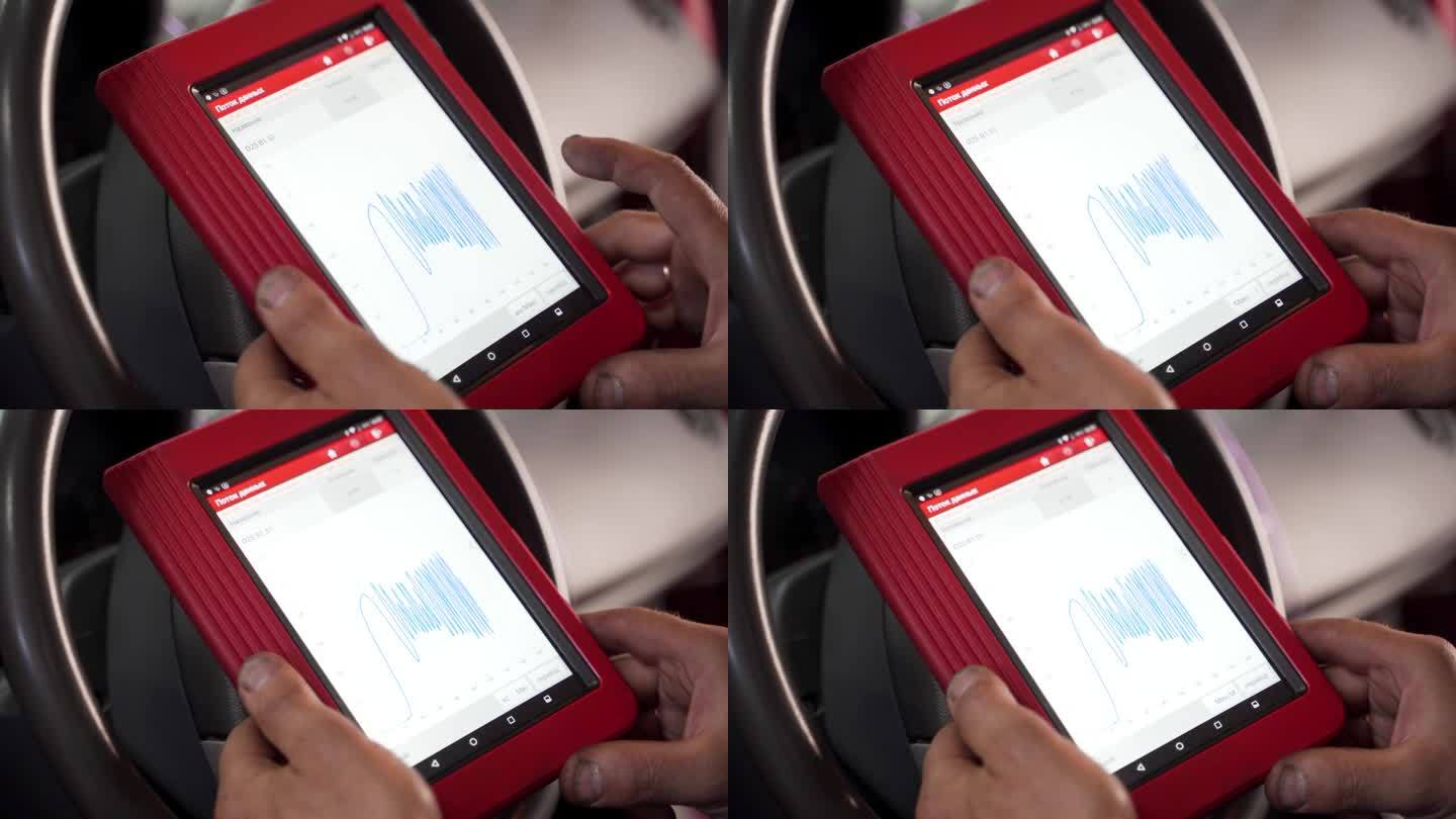 汽车技师使用OBD2扫描仪和平板电脑检查车辆发动机代码。诊断工具无线传输数据，对车间内的汽车进行故障