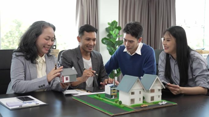 房地产经纪人正在讲解房屋模型查看房屋平面图和买卖合同，房屋买卖合同的条件，与客户合法签订合同。