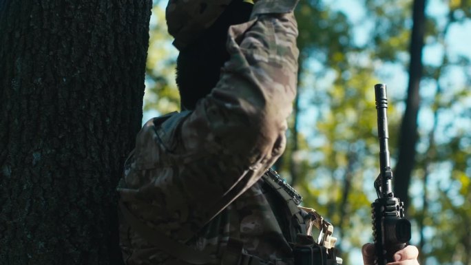 疲惫的士兵靠在森林里的一棵树上摘下帽子