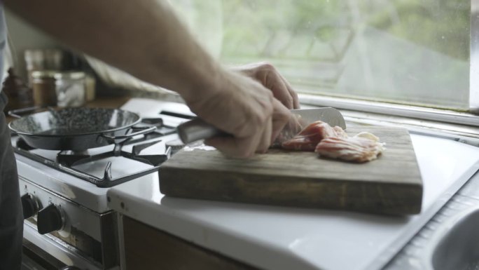 人，烹饪和厨房用培根，切和厨刀在家里，准备和食物。早餐，脂肪和煎锅与蛋白质，生肉和砧板在早上，手和饭