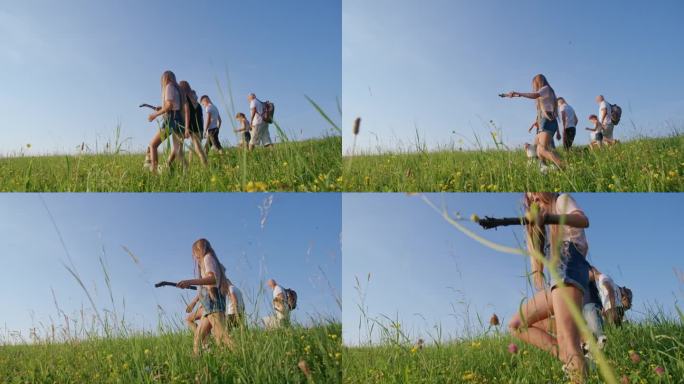 孩子和老人远行的背影，在高高的草丛中散步，和狗玩耍，游客享受大自然和夏日的好天气。徒步旅行的概念