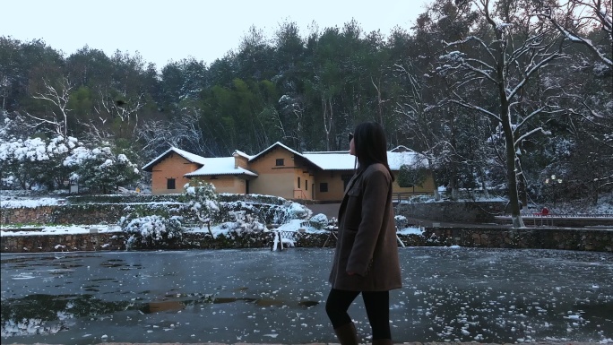 雪后跟拍美女游客行走在毛泽东故居前