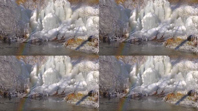 从破裂的管道流出的水在河边形成了冰的形状