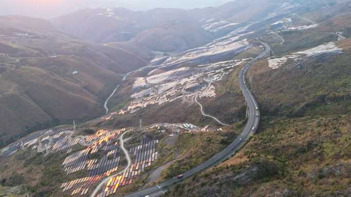 航拍夕阳下高速公路旁的光伏太阳能电池板