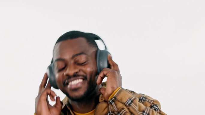 耳机，跳舞或快乐的黑人在白色背景的工作室里听着自由的音乐。微笑，兴奋或非洲人流媒体广播歌曲，声音或音