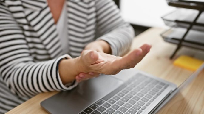 一名中年妇女在办公室工作时手腕疼痛，可以看到她的手势，这可能是腕管综合症。