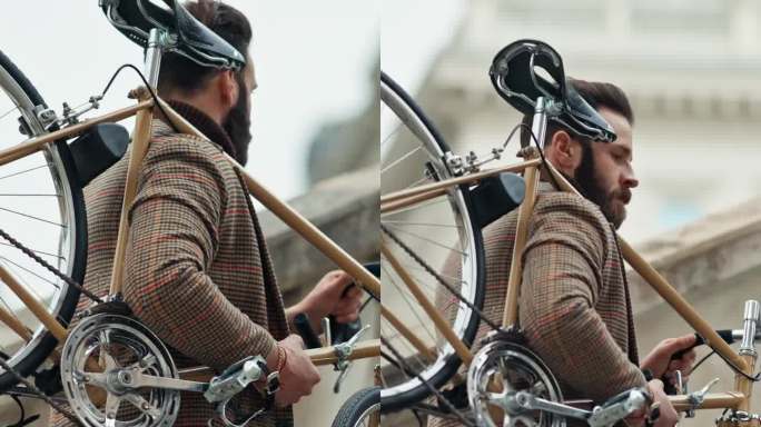 年轻时尚的男子扛着他的自行车上楼，在阳光明媚的日子里骑着复古的自行车。