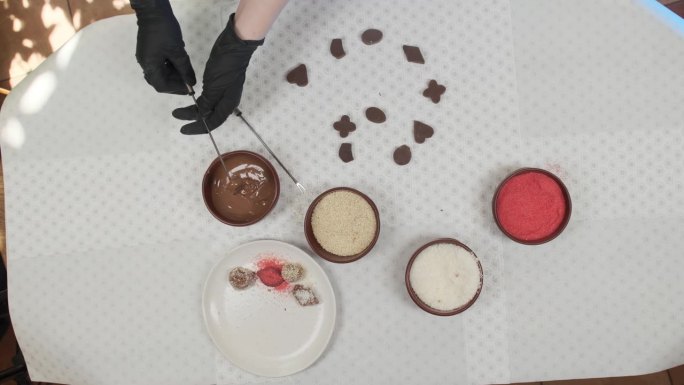厨师把糖果浸在巧克力里，然后裹上细碎的椰子